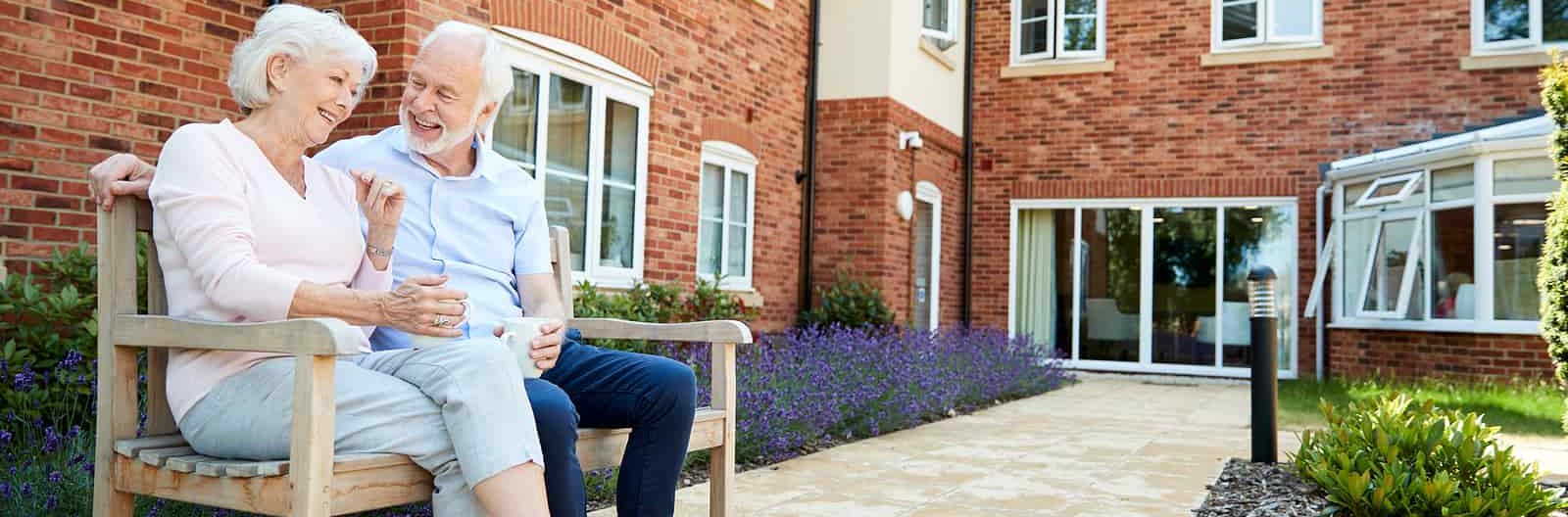 elderly couple sitting on bench